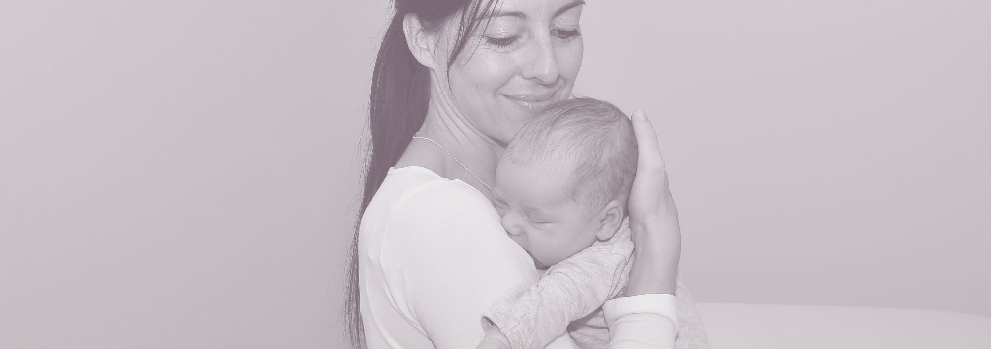 Foto von Angelika Leitner, die ein Baby auf dem Arm hält