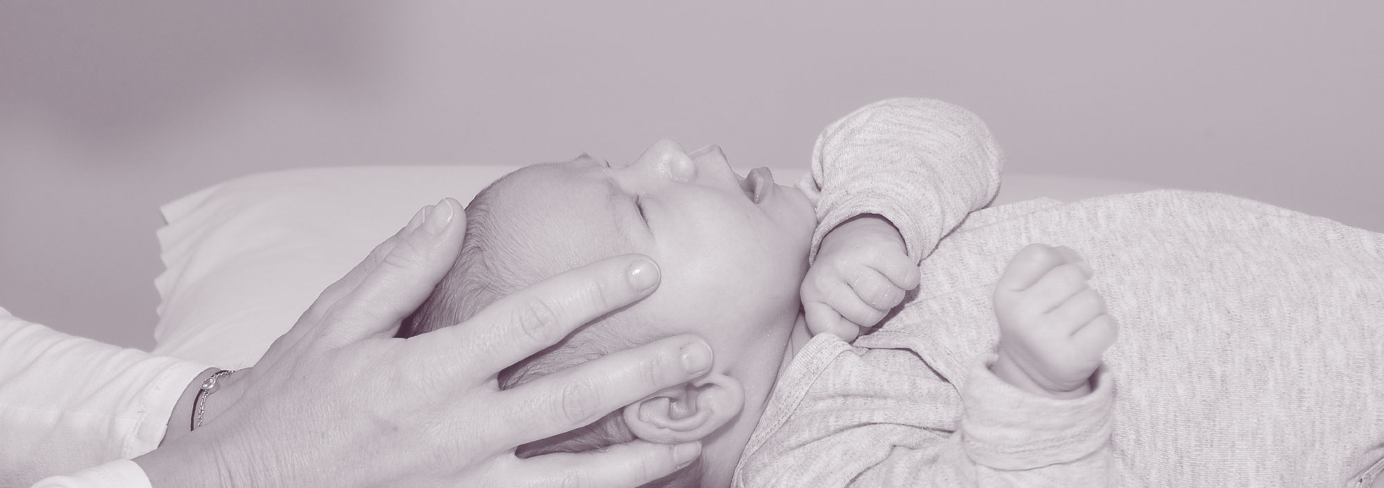 Foto von einem Baby, das am Kopf gestreichelt wird